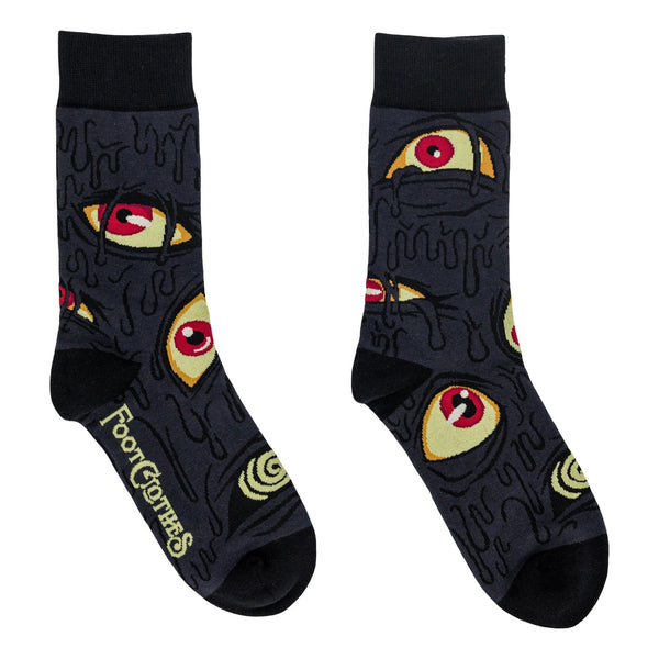 A pair of unisex cotton blend greyish black background crew socks with a repeating pattern of stylized eyes in yellow with red pupils and dripping oozing shapes. Shown flat