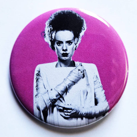 1.25" pinback button of a photograph of Elsa Lanchester as the Bride of Frankenstein on a hot pink background