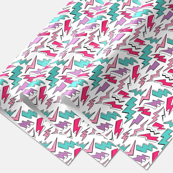 matte finish gift wrap in an all-over teal, purple, pink & white with black outline lightning bolt pattern on a white background. Shown overlapping with three sheets