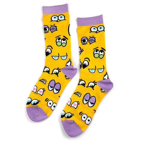 Crew socks with sets of cartoon eyes on a golden yellow background with lavender cuffs, heels, and toes. Shown flat 