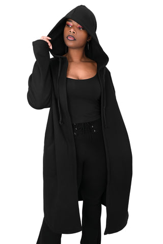 model wearing a black fleece longline open front hoodie sweater with oversized hood with drawstring, long sleeves with thumbholes, and pockets. Shown from front with hood up