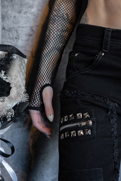 model wearing crew neck black fishnet long sleeve top with thumb holes. Shown from front in close up of thumb hole detail