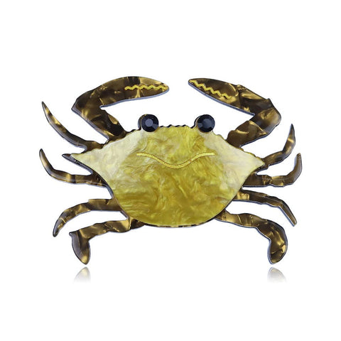 acrylic resin brooch of a crab in a golden rippled pattern with black jeweled eyes and dark contrasting claws and legs.