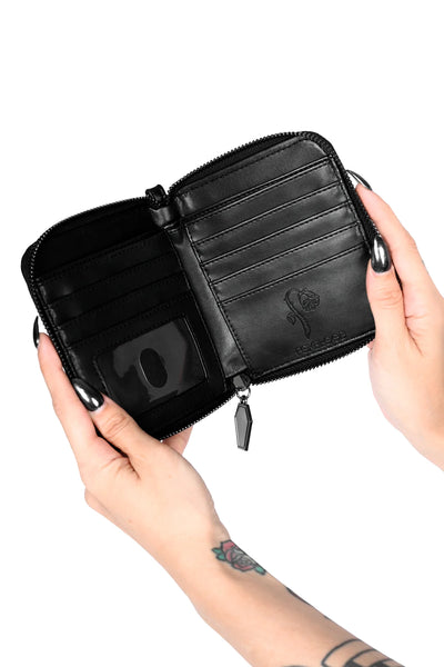 Model holding black faux leather rectangular wristlet wallet with black vinyl bat scattered pattern and matching wrist strap. Shown open to display credit card slots, ID window, and bill pockets