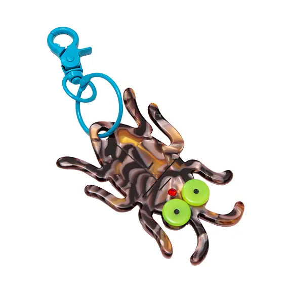 Acrylic swirled brown and black cockroach-shaped keychain with large lime green eyes and red rhinestone mouth on a bright blue enameled metal swivel keychain