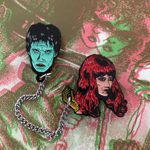 The Cramps' Lux Interior & Poison Ivy Rorschach here as enameled black metal clutch back pins connected by a 4" silver metal chain