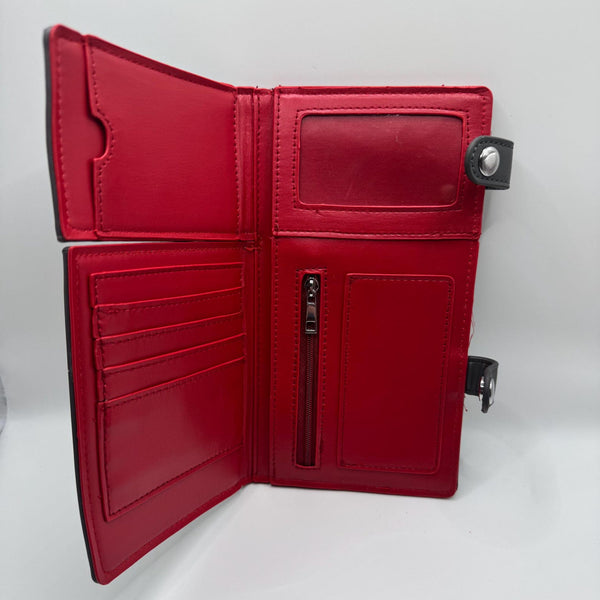 black faux leather wallet in the shape of a casket with two separate silver metal snap closures to replicate the headpanel and footpanel. Shown with both compartments open from front