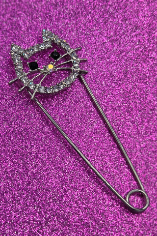 silver metal safety pin with pin closure in the shape of a cat head with clear "rhinestone" jewels & black jewels for eyes