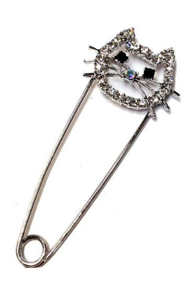 silver metal safety pin with pin closure in the shape of a cat head with clear "rhinestone" jewels & black jewels for eyes shown on white background