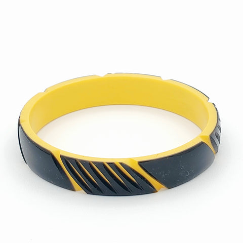 black and straw resin bangle in a carved diagonal “cinched” stripe motif