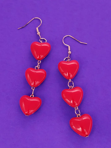 Dangle earrings of three red acrylic puffy hearts connected to each other