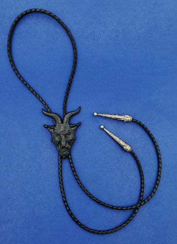 A black enameled metal goat pendant bolo tie with red eyes on a black braided leather cord