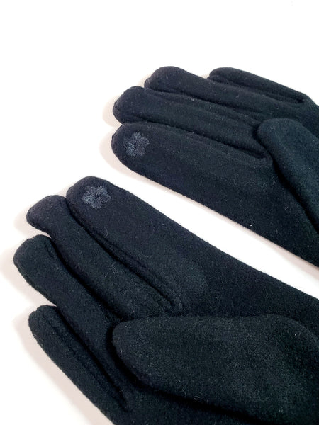 Pair of black knit gloves with matching soft faux fur heart-shaped cuff detail, showing close up view of reverse with texting fingertip