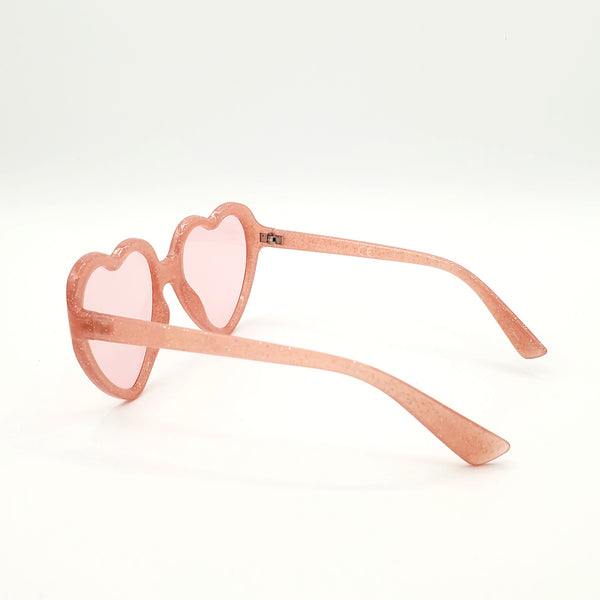 Pale semi-translucent pink with silver glitter plastic frame heart-shaped sunglasses with matching rose pink lenses. Showing reverse in 3/4 view