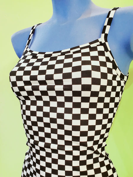 black and white checker print bodycon mini dress with spaghetti straps. showing bust close up on a blue mannequin