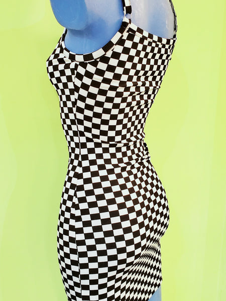 black and white checker print bodycon mini dress with spaghetti straps. shown 3/4 back view on a blue mannequin