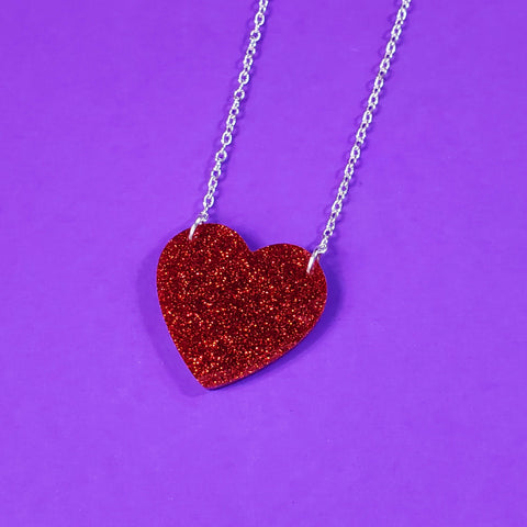 sparkly red glitter heart shaped acrylic resin pendant attached to a silver plated curb style chain