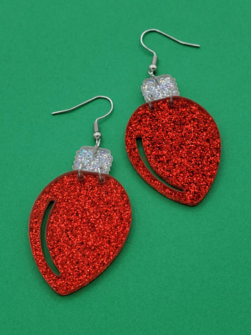 glittery laser cut acrylic earrings in the shape of red Christmas lights