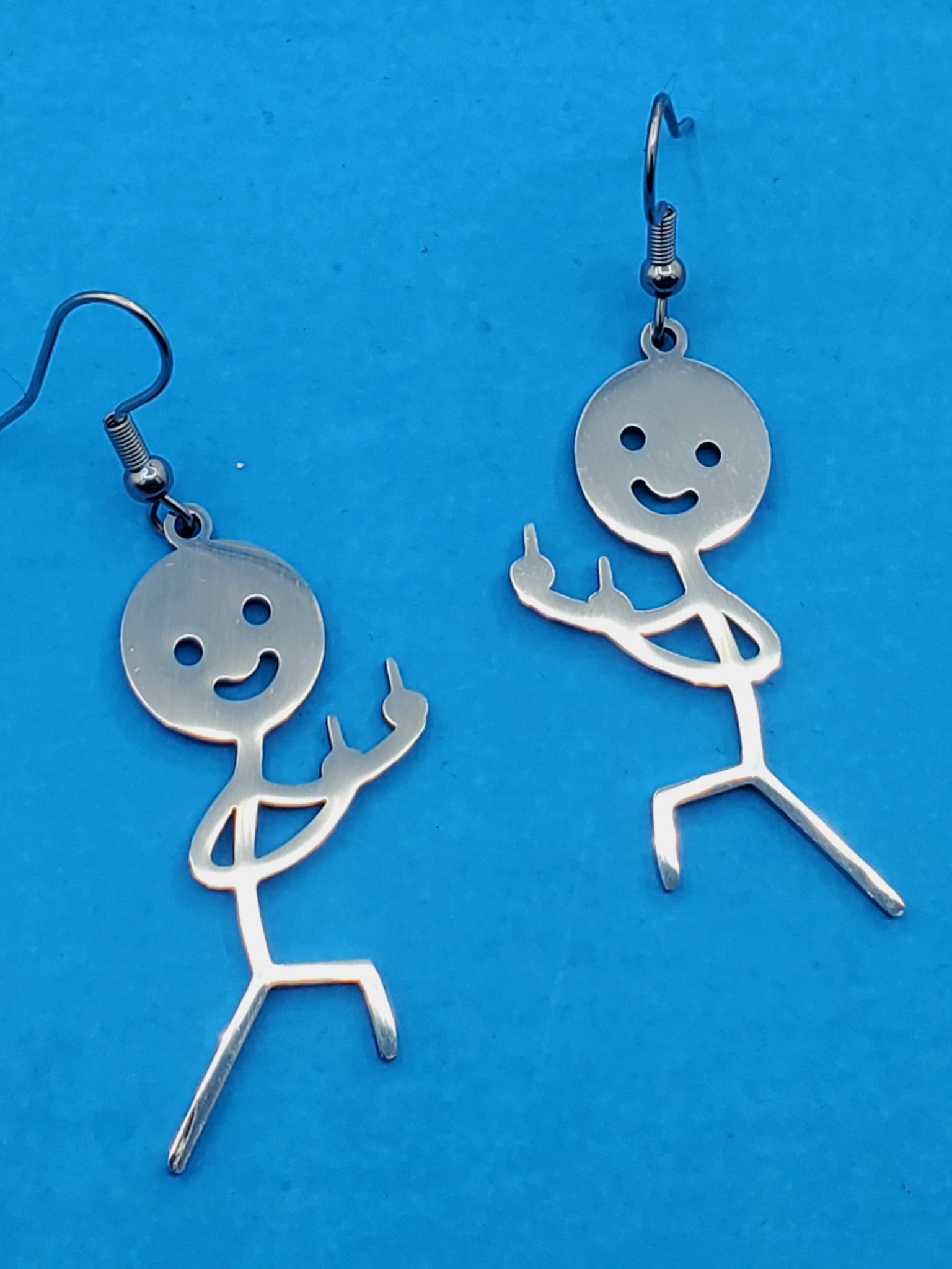 pair of stainless steel dangle earrings with charms in the shape of stick figures with smiley faces flipping the bird in mirror image