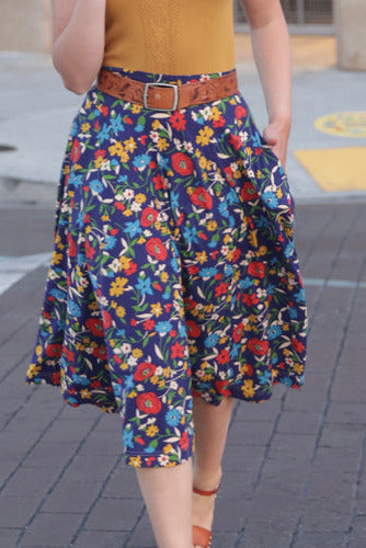 Person wearing a colorful floral skirt on a street.