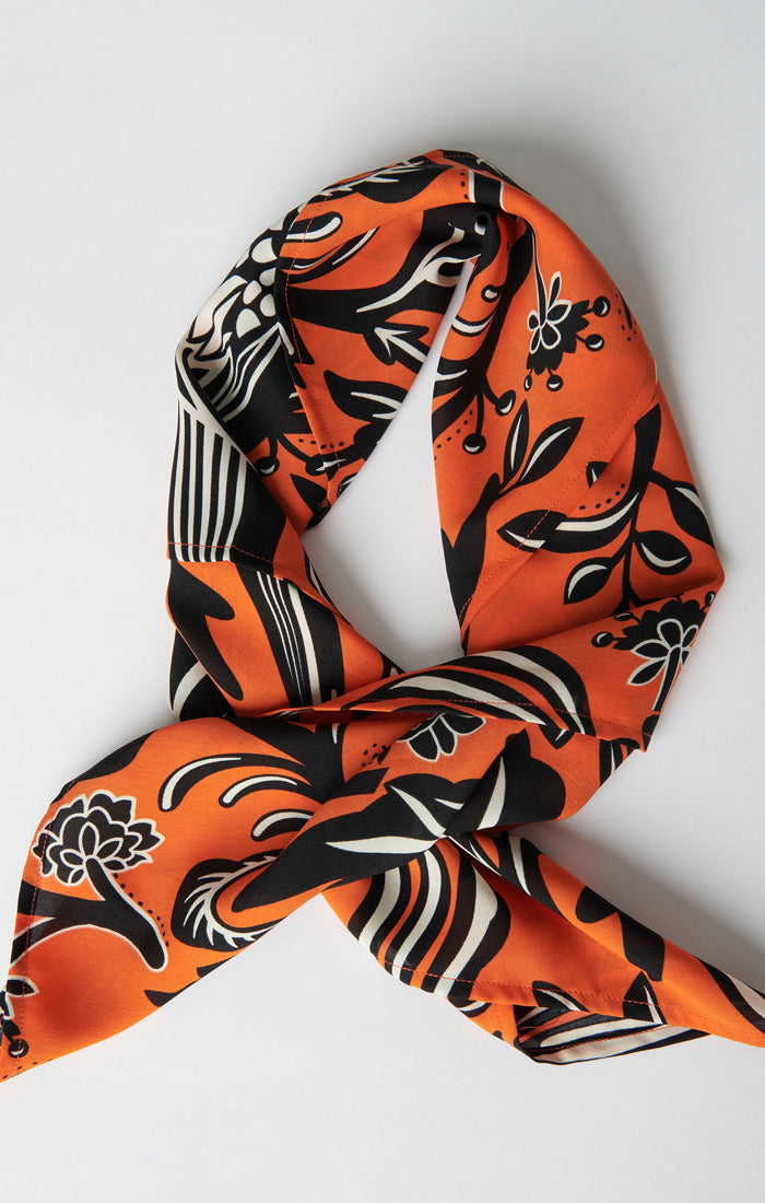 Vintage inspired semi-sheer black, orangey red and white chiffon square scarf in a floral pattern with a black and white parrot 