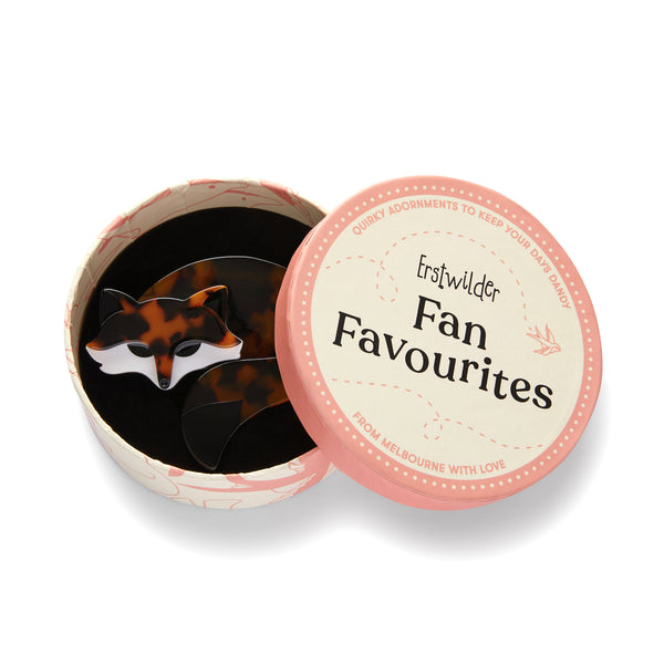Fan Favourites Collection "Saffron the Sleeping Fox” black, white, and tortoiseshell fox brooch shown in illustrated round gift box