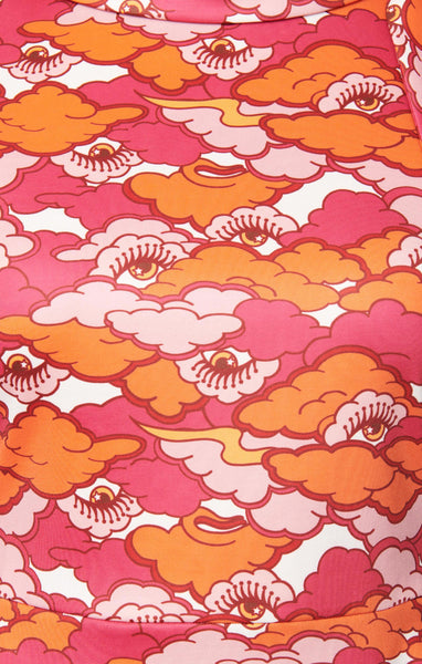 fabric swatch close up of 60s style fit & flare sleeveless mini dress iin an illustrated pattern of eyes gazing at you from a creamy sky filled with pink and orange clouds