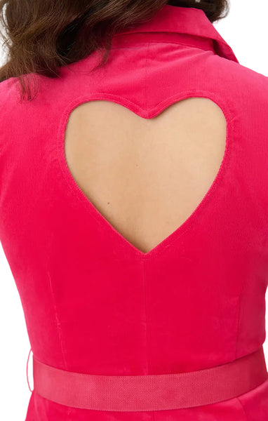 Model wearing a hot pink lightweight corduroy romper with pointed collar, cap sleeves, slight v-neckline, front zip closure, heart cutout at back, matching canvas belt with gold heart buckle, side seam pockets, and shorts. Shown from back in close up of heart cutout detail