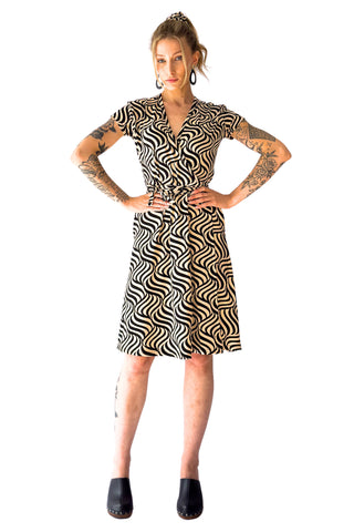ivory and black swirly optical print cap sleeve knee length wrap dress, shown front view on a model