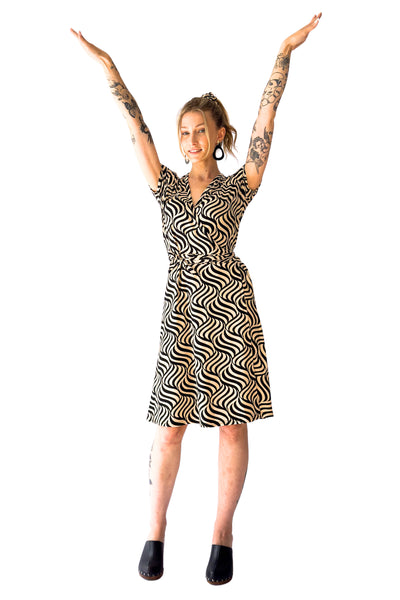 ivory and black swirly optical print cap sleeve knee length wrap dress, shown front view on a model