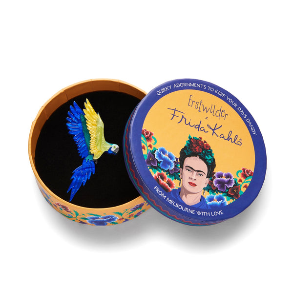 Frida Kahlo Collection “Frida's Parrot” blue and yellow bird in flight layered resin brooch, shown in illustrated round box packaging