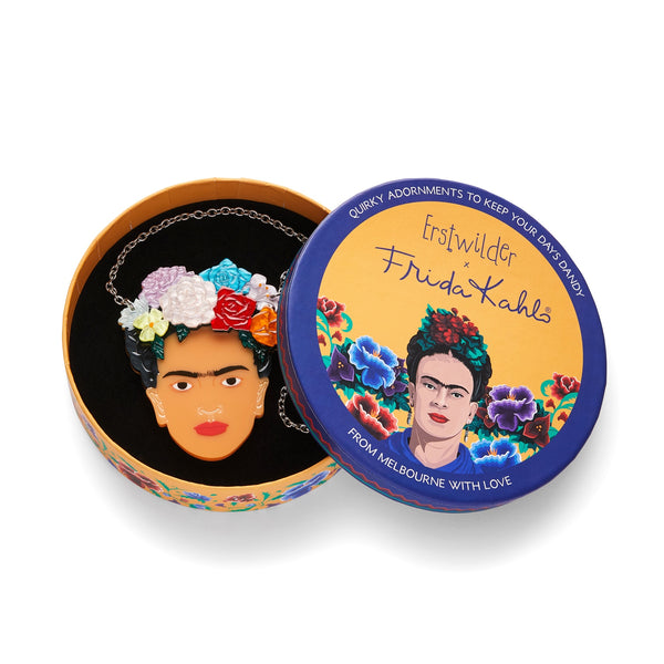 Frida Kahlo Collection “My Own Muse Frida” layered resin portrait pendant necklace, showing Frida wearing multicolor flowers in her hair, packaged in illustrated round giftbox