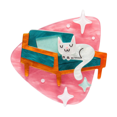 Atomic Abode Collection "Susan the Sleeping Kitty" white cat on teal chair against pink rounded triangle shape mid-century style layered resin brooch