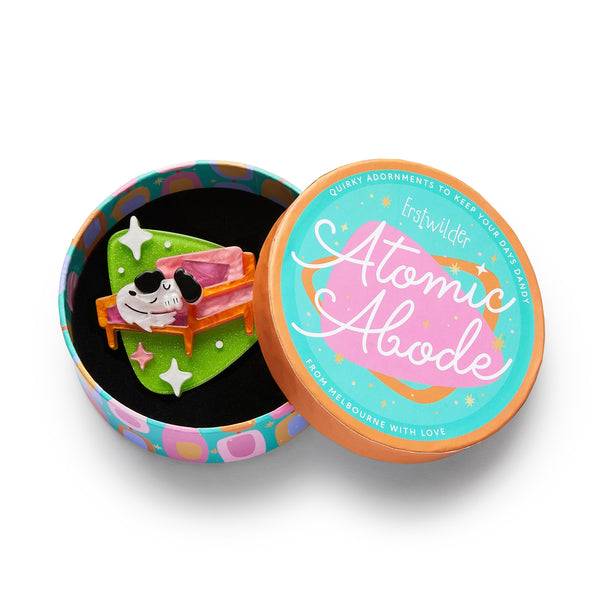 Atomic Abode Collection "Richard the Resting Pooch" white and black dog sleeping on pink chair against green rounded triangle shape mid-century style layered resin brooch, shown in illustrated round box packaging