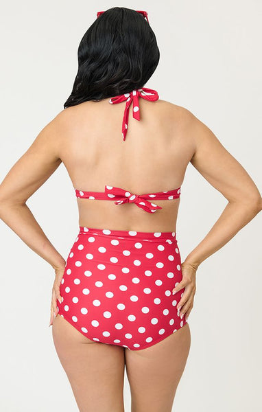 Red and white polka dot patterned halter style bikini top with front bow detail, shown on model from back