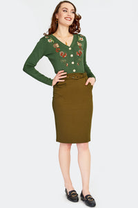 a model wearing a warm brown knit high-waisted pencil skirt with a self fabric belt and front pockets with notch details. Shown from the front