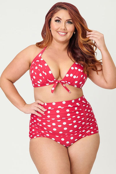 Red and white polka dot patterned halter style bikini top with front bow detail, shown on plus size model from front