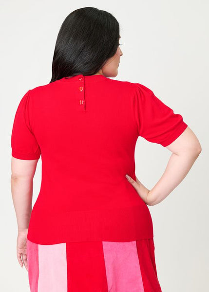 back view of bright red short sleeve sweater featuring heart-shaped button closure at nape. shown on a plus size model