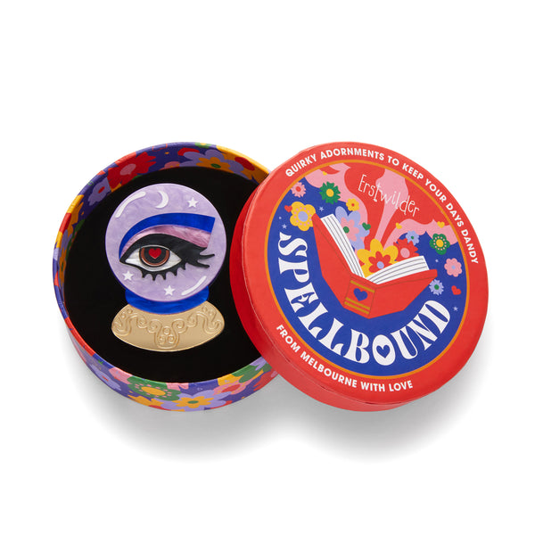 Erstwilder's Spellbound collection "Keen-Eyed Insight" crystal ball with eye inside layered resin brooch, shown in illustrated round box packaging