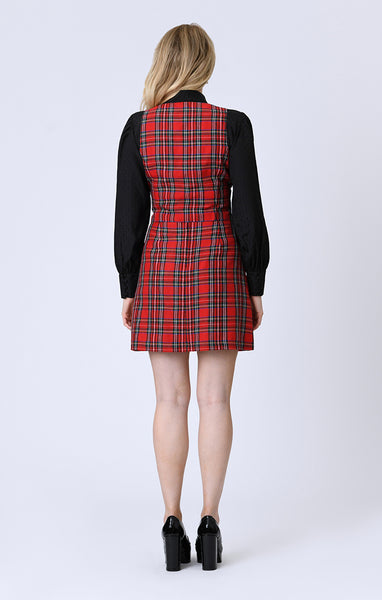 Woman wearing an a-line red plaid mini skirt with patch pockets on a white background. Shown from behind