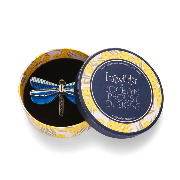 Jocelyn Proust Collaboration Collection "Sapphire Sky Dancer" layered resin dragonfly brooch, shown in illustrated round box packaging