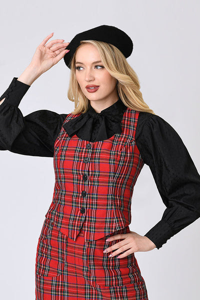 model wearing a red plaid vest with vertical seaming, a round neckline, and black button closure. Shown layered with black blouse from front