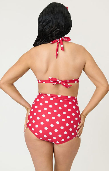 Bright red and polka dot patterned 50s style high-waist ruched front swim bottoms, shown on model from back