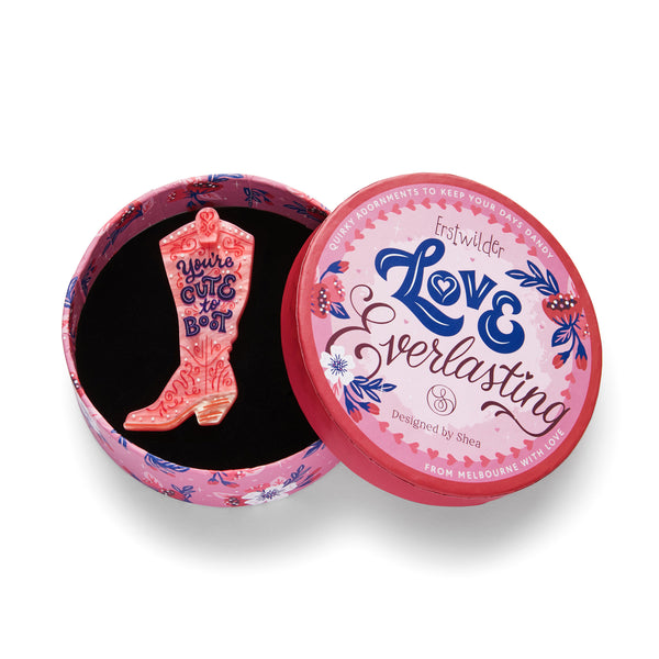 Love Everlasting Shea O'Connor collaboration collection "Cute to Boot" pink cowgirl boot with purple "You're Cute to Boot" text layered resin brooch, shown in illustrated round box packaging