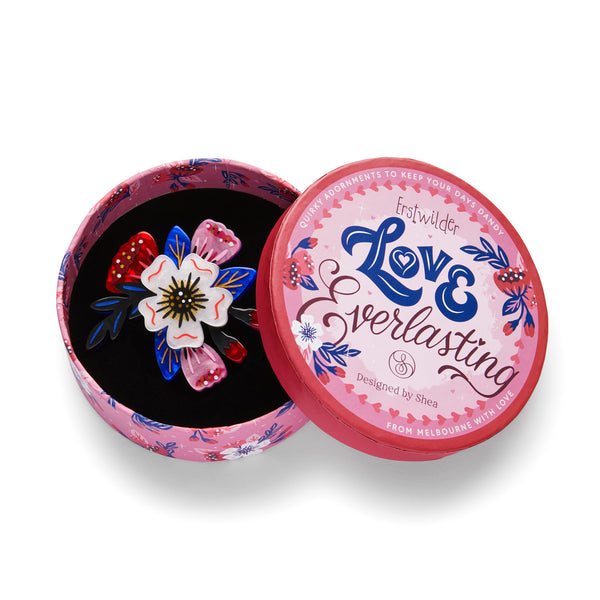 Love Everlasting Shea O'Connor collaboration collection "Say It With Flowers" red, white, pink, black, and blue flower bouquet layered resin brooch, shown in illustrated round box packaging