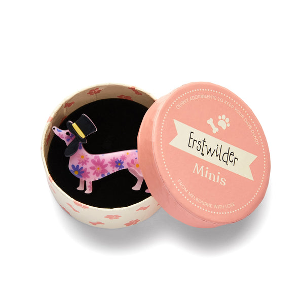 Dog Minis Collection "Dapper Dachsund" standing pink floral patterned dachshund in a top hat layered resin brooch, shown in illustrated round box packaging