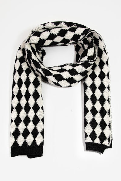 A knit black and creamy white scarf in a Harlequin pattern