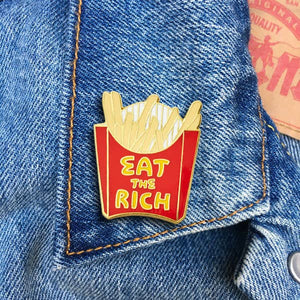"Eat the Rich" fast food fries enameled gold metal clutch back pin, shown on denim jacket collar