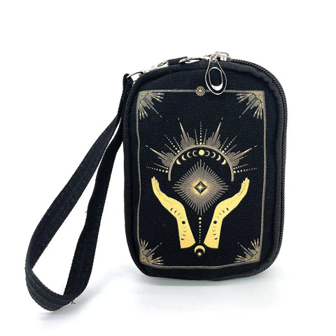 Black canvas rectangular pouch printed with a metallic gold design of a pair of hands and abstract moon phases surrounded by a starburst design and an Art Deco style rectangular border. Has two zipper closure compartments, and detachable wristlet strap. Shown from the front