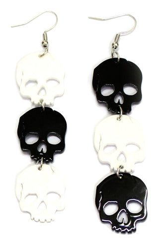 A pair of acrylic laser cut dangle earrings with alternating black and white skulls
